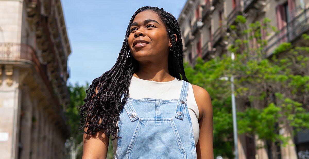 Woman between houses looking up right