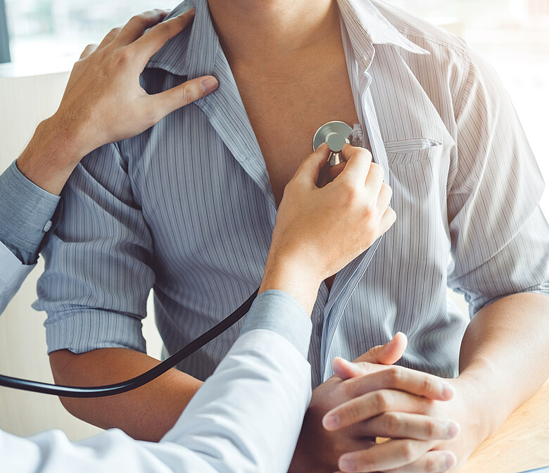 Clinician listens to a patient’s chest with a stethoscope during a routine exam.