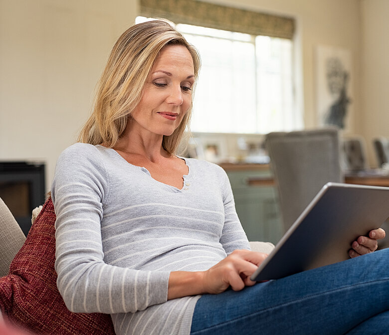 Woman sitting on couch working on her laptop